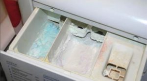 How to clean the washing machine tray from fossilized powder?