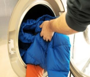 Een donsjack van bio-dons wassen in een wasmachine