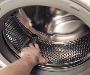 How should a washing machine drum rotate by hand?