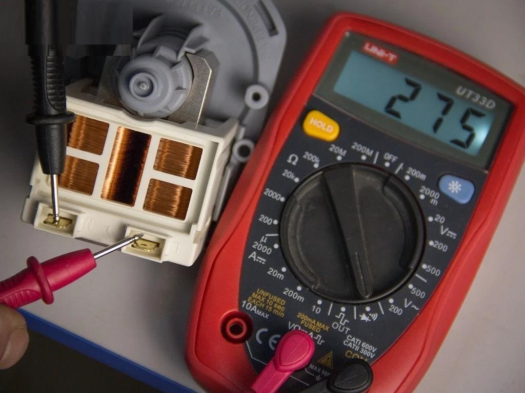 Memeriksa pam saliran mesin basuh dengan multimeter